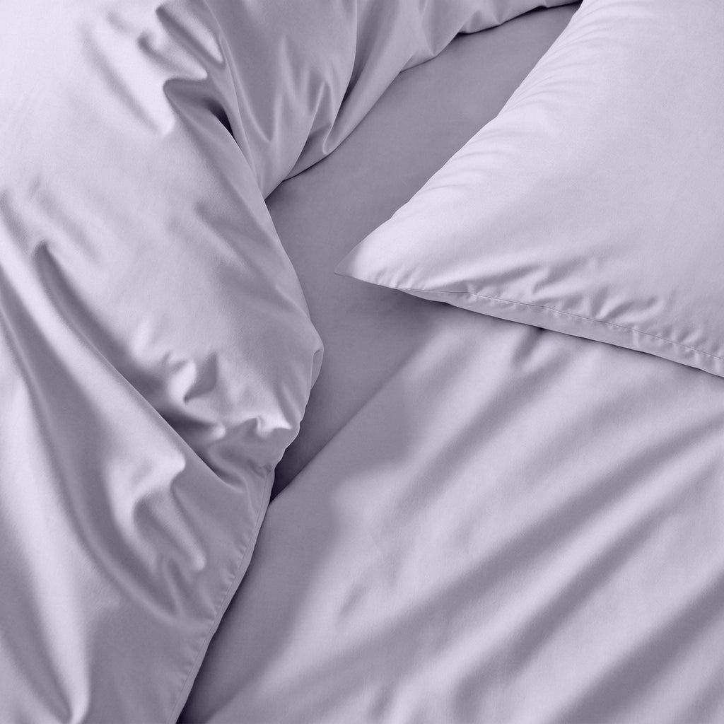 Lilac sateen duvet cover close-up, smooth satin-like fabric with subtle sheen