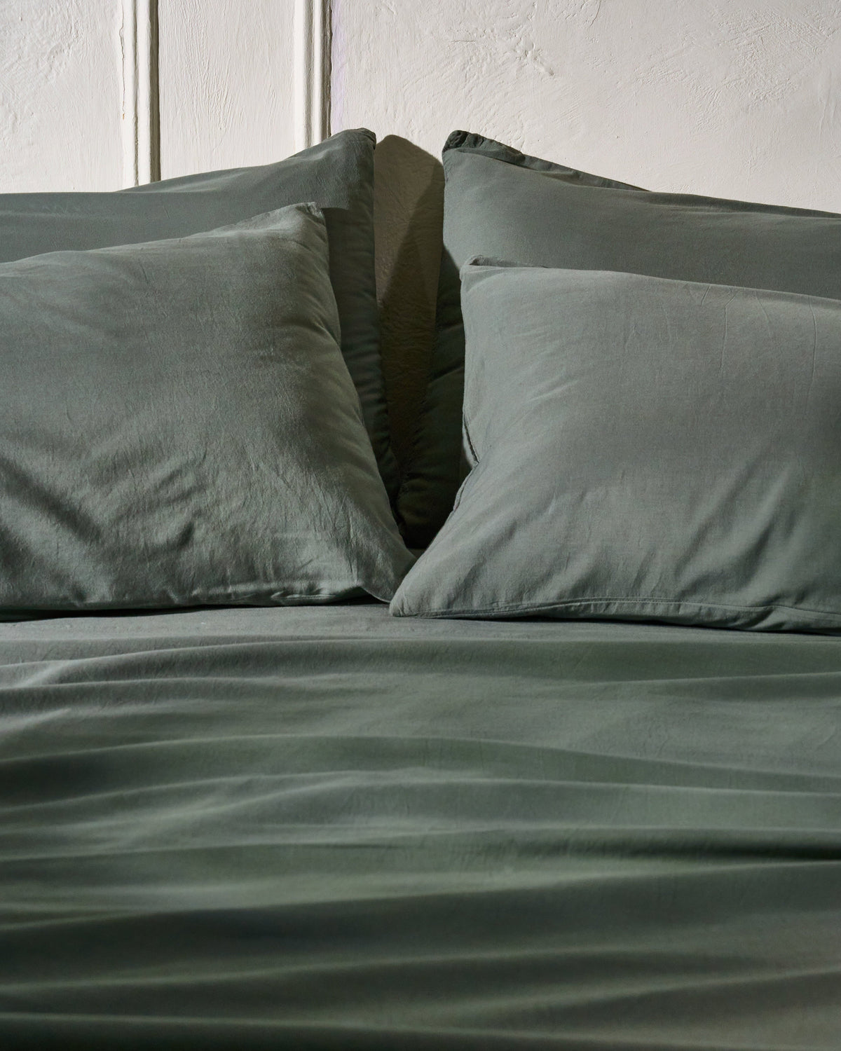 Highlands green milk-fibre pillowcase set on bed, two pillowcases shown