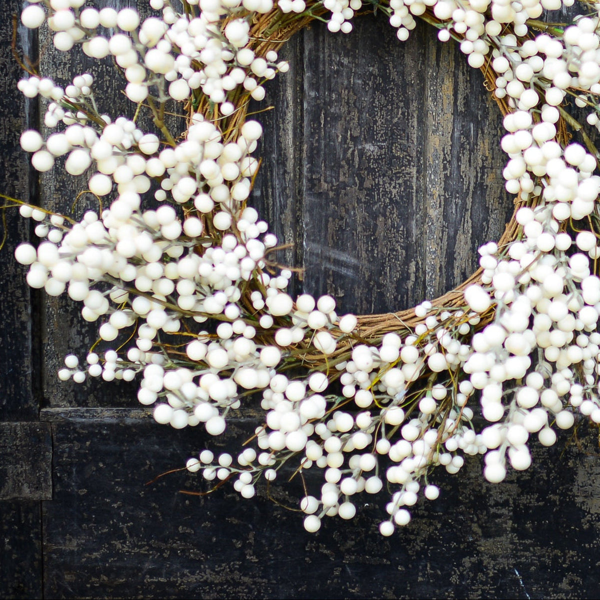 Close-up cream berry wreath showing dangling bead-like berry clusters around the ring