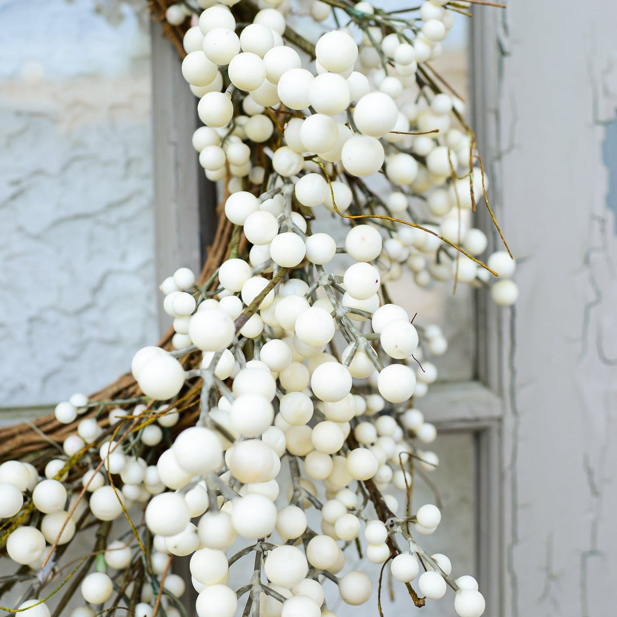 Cream berry wreath detail with many small white berry beads draping over a twig ring