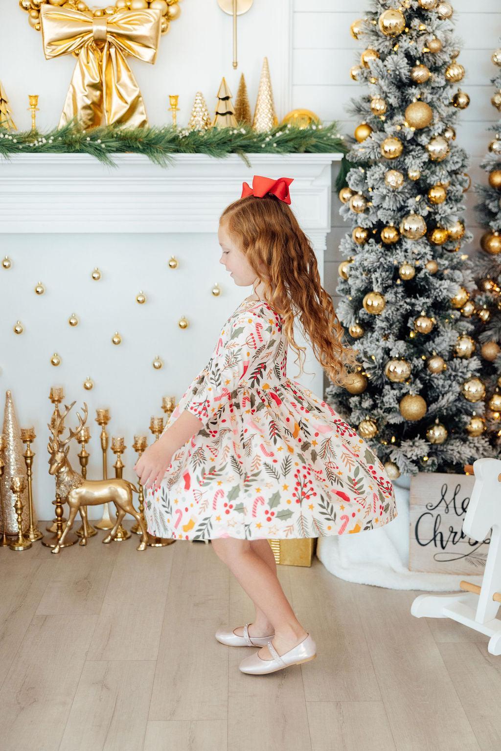 Girls’ twirl dress with long flare skirt; white fabric with red, green, gold print