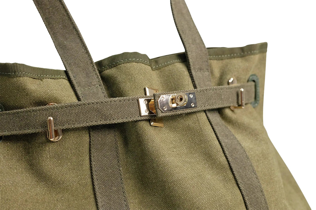 Olive canvas tote bag with front belt strap and gold-tone buckle hardware