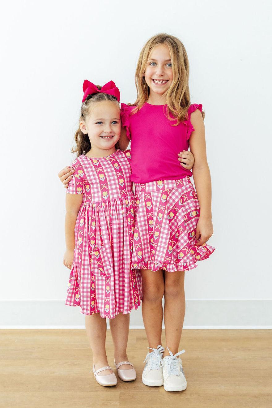 Girls' pink twirl skort with bow accents and heart-and-tulip check ruffle skirt hem