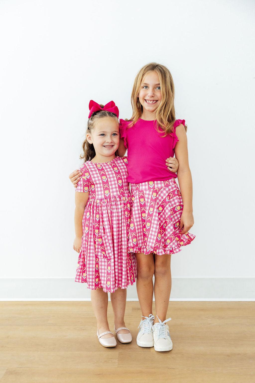 Girls pink plaid twirl dress with tulip and bow print, short sleeves, flared twirl hem