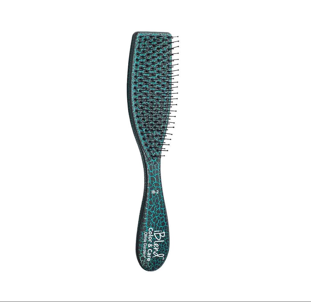 Green paddle hair brush with mixed bristles and curved cushioned handle.