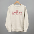 Cream sweatshirt with red "I love you to the library and back" graphic
