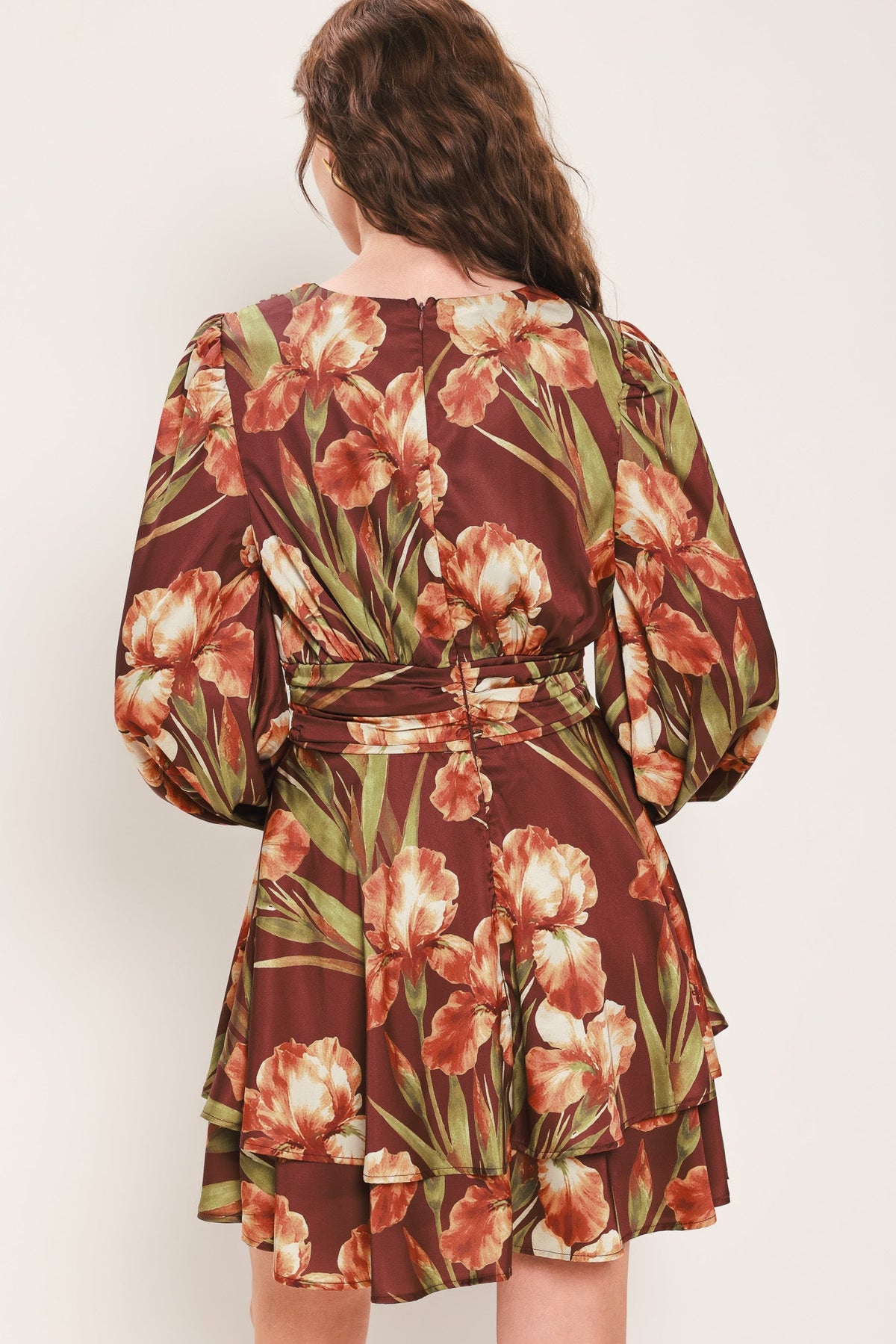 Floral mini dress back view with long puff sleeves, ruched waist belt, tiered skirt.