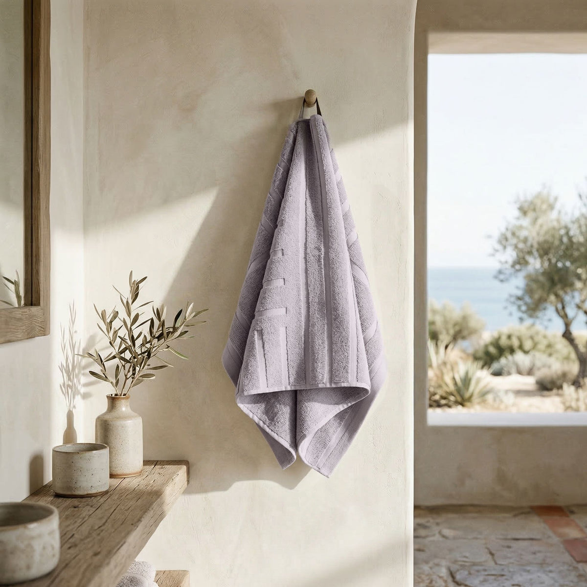 Lilac cotton hand towel hanging neatly with textured stripe bands