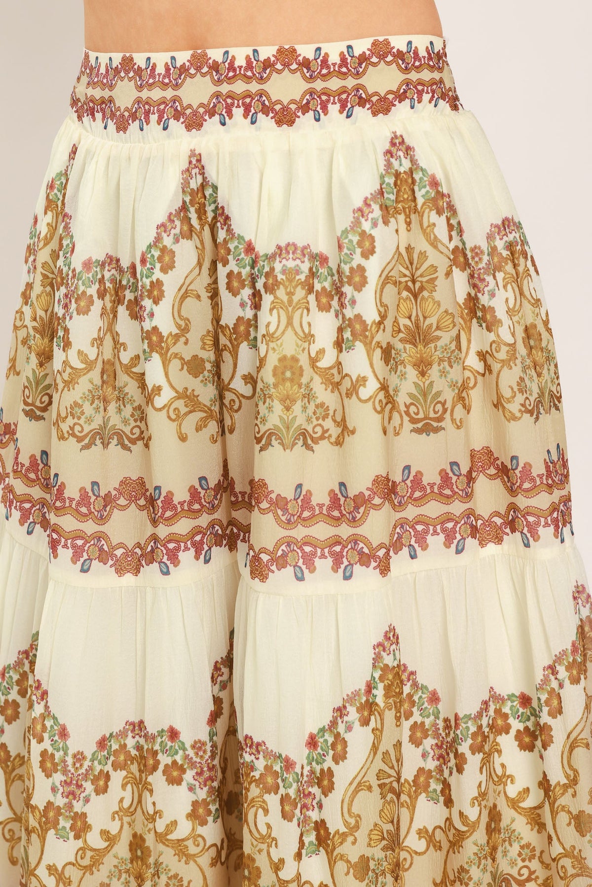 Ivory tiered maxi skirt detail with gold scroll print and red border trim