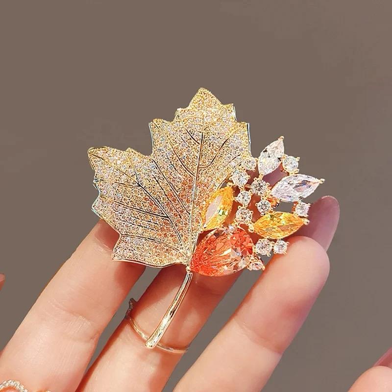 Gold-tone autumn foliage brooch with orange and white leaf crystals and green detailing, pin back