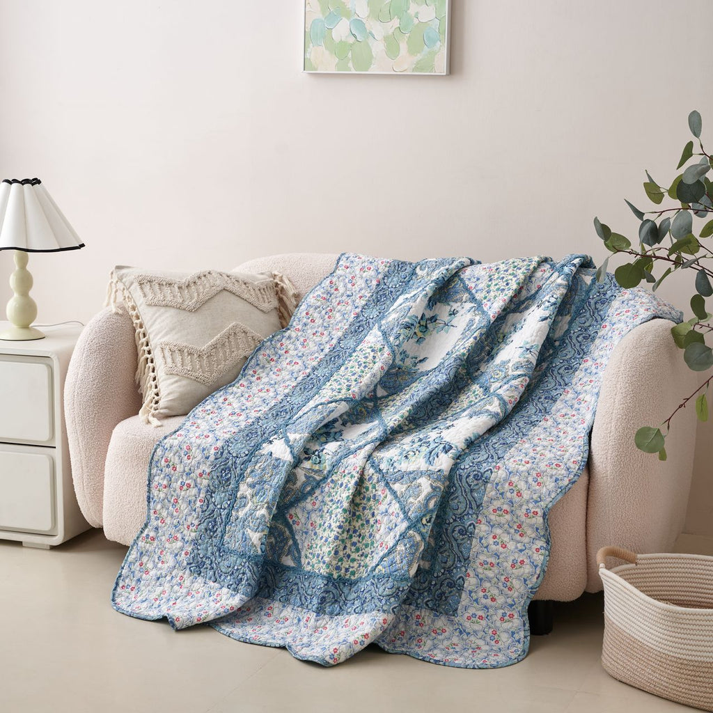 Floral patchwork quilt throw blanket in blue and white with gathered scalloped edge