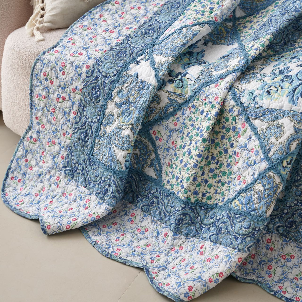 Close-up of blue floral patchwork quilt blocks with quilted texture and stitches