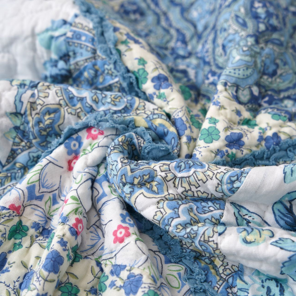 Blue and white floral patchwork quilt throw blanket, folded