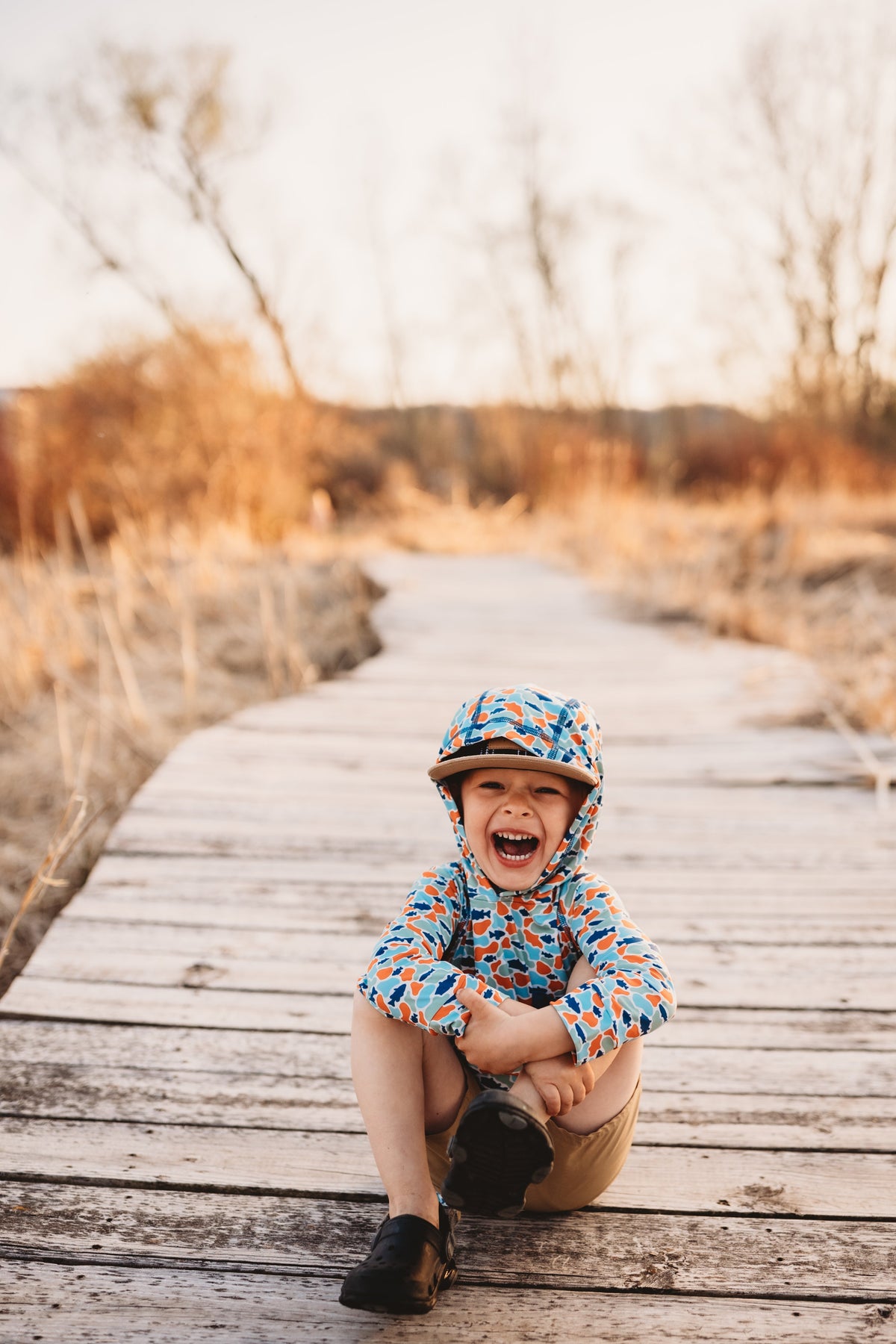 Kids hooded UV cover-up with fish-camo print, front pocket, teal and orange