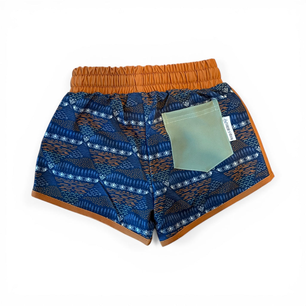 Blue patterned shorts with orange waistband and hanging tag in front pocket