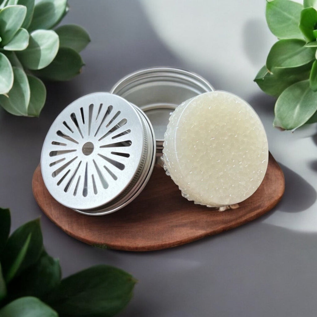 Scented wax refill tin with open lid and round white wax puck on base