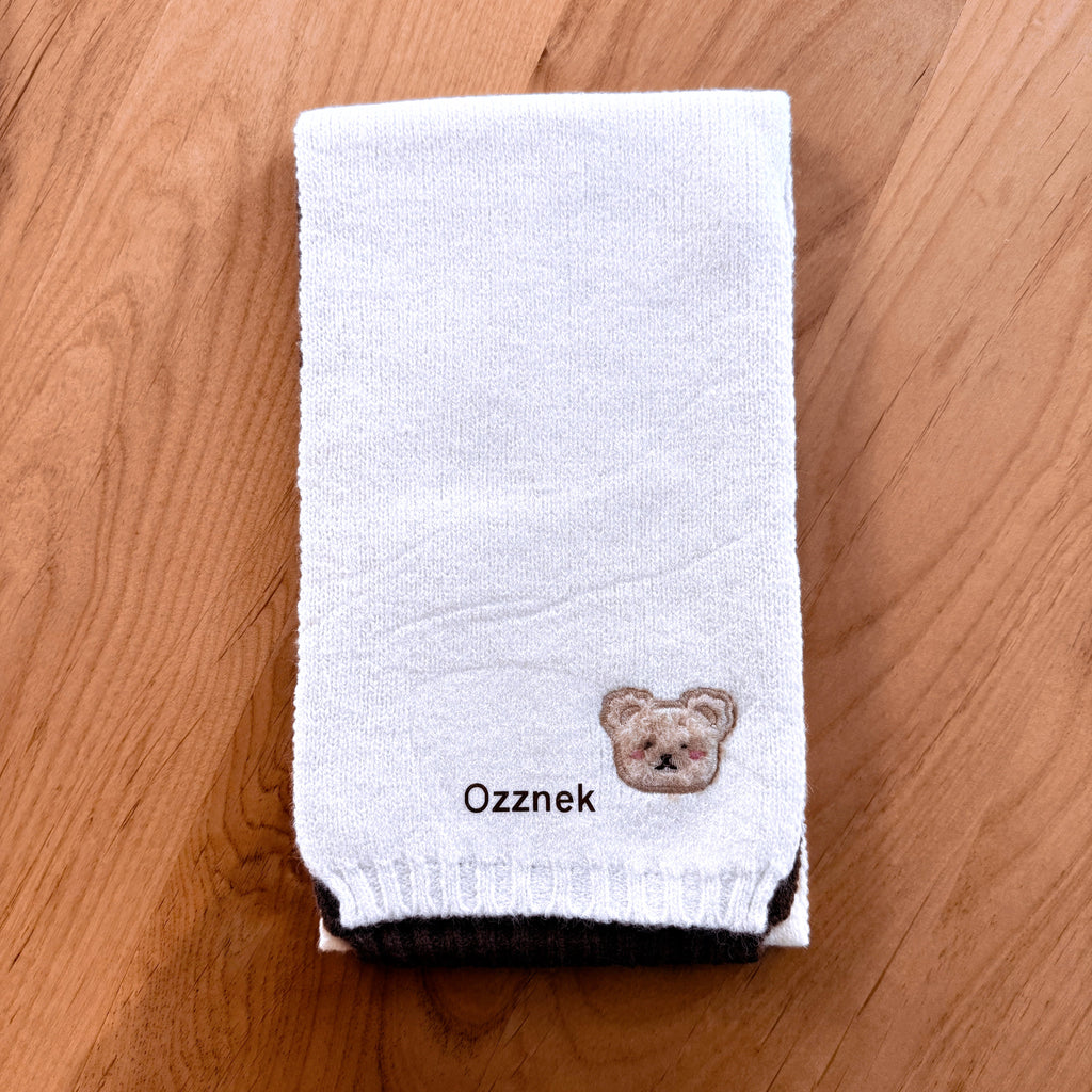 White toddler knitted scarf with bear emblem and ribbed hem