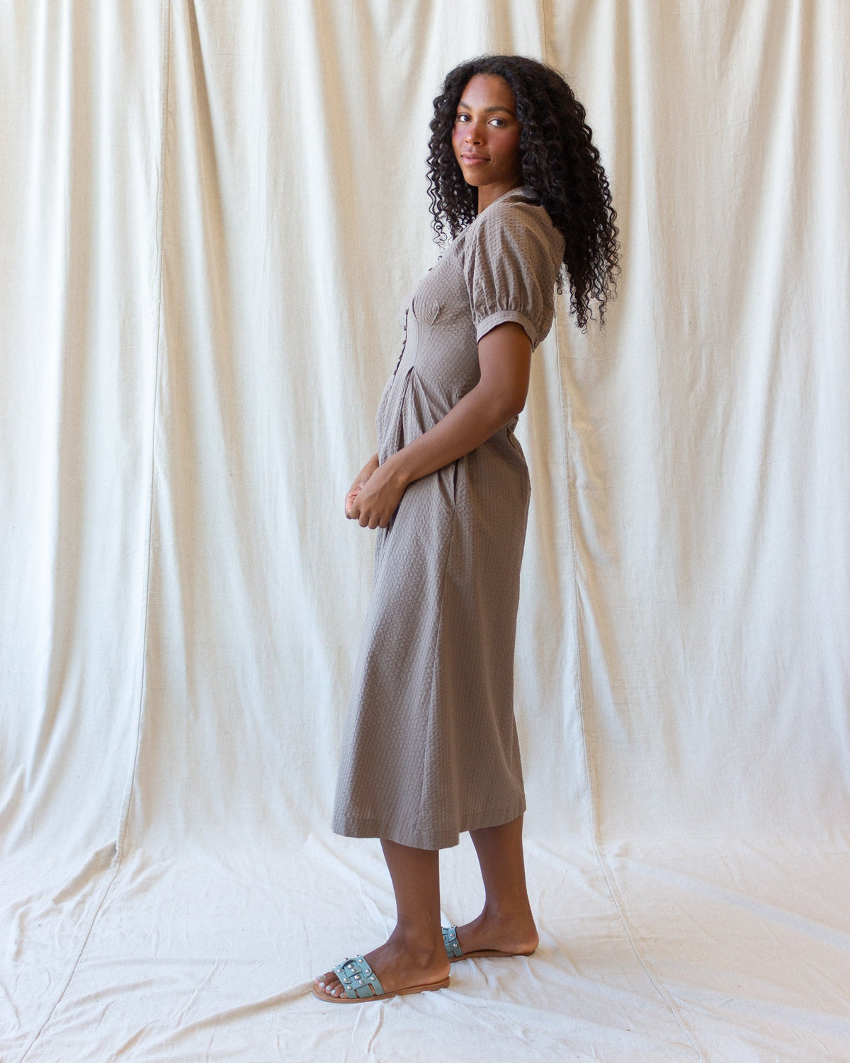 Women's field dress in pine bark, side view midi with button placket and short puff sleeves
