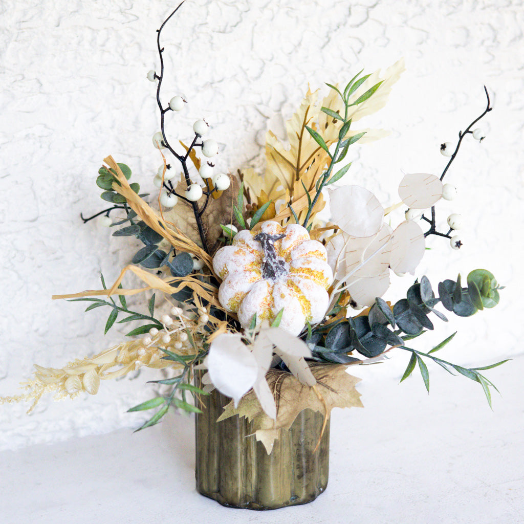 Floral arrangement with white blooms, gold-speckled center, eucalyptus, and ribbon-like dried grass in vase
