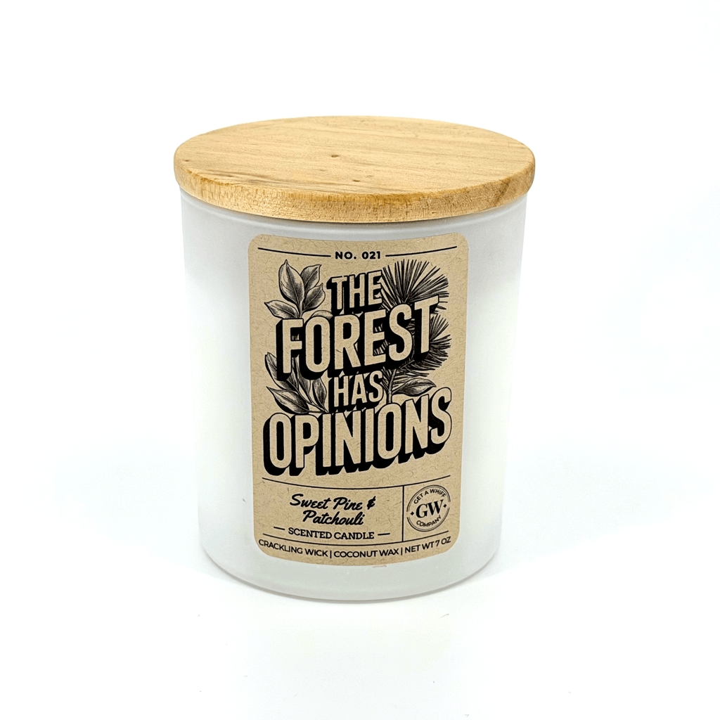 White scented candle jar with wood lid and “The Forest Has Opinions” label
