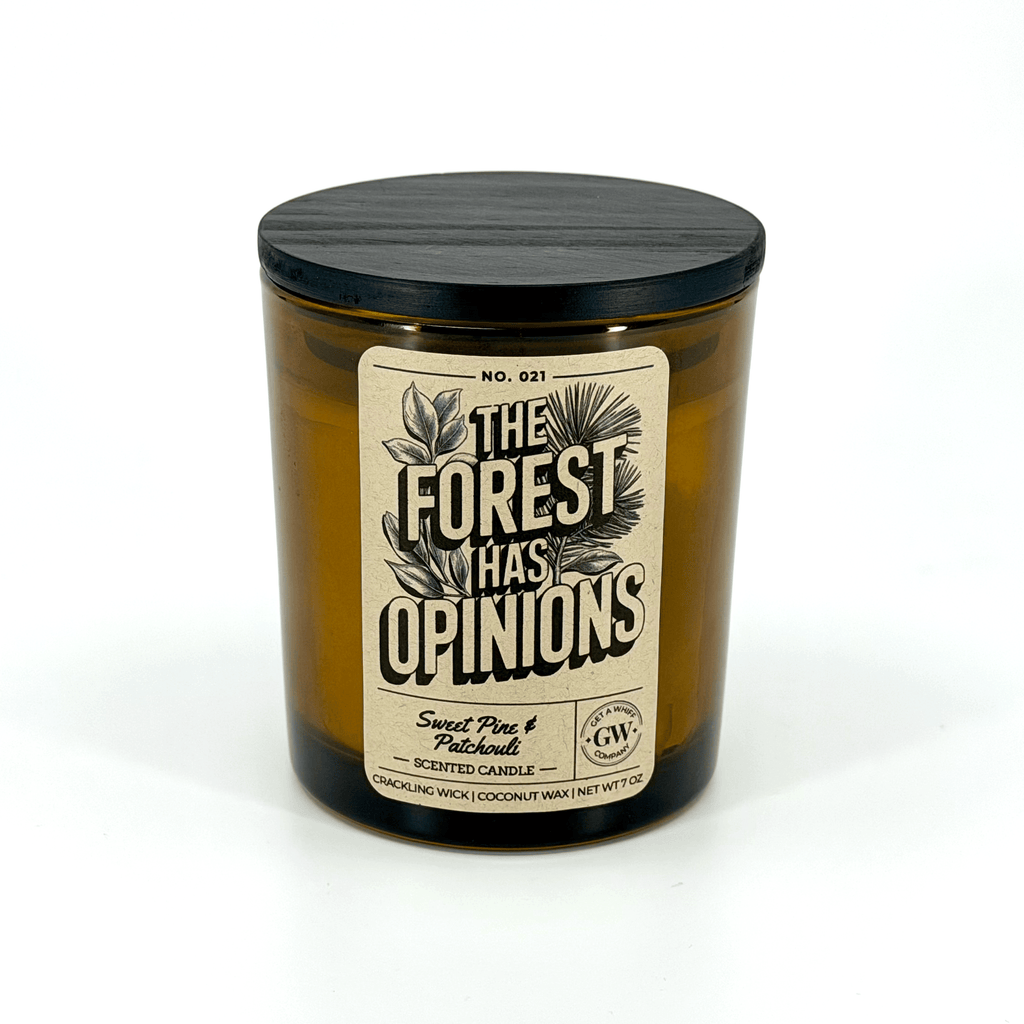 Amber scented candle jar with dark lid and “The Forest Has Opinions” label