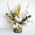 Floral arrangement with white and gold-speckled bloom, eucalyptus, and greenery in a ribbed vase