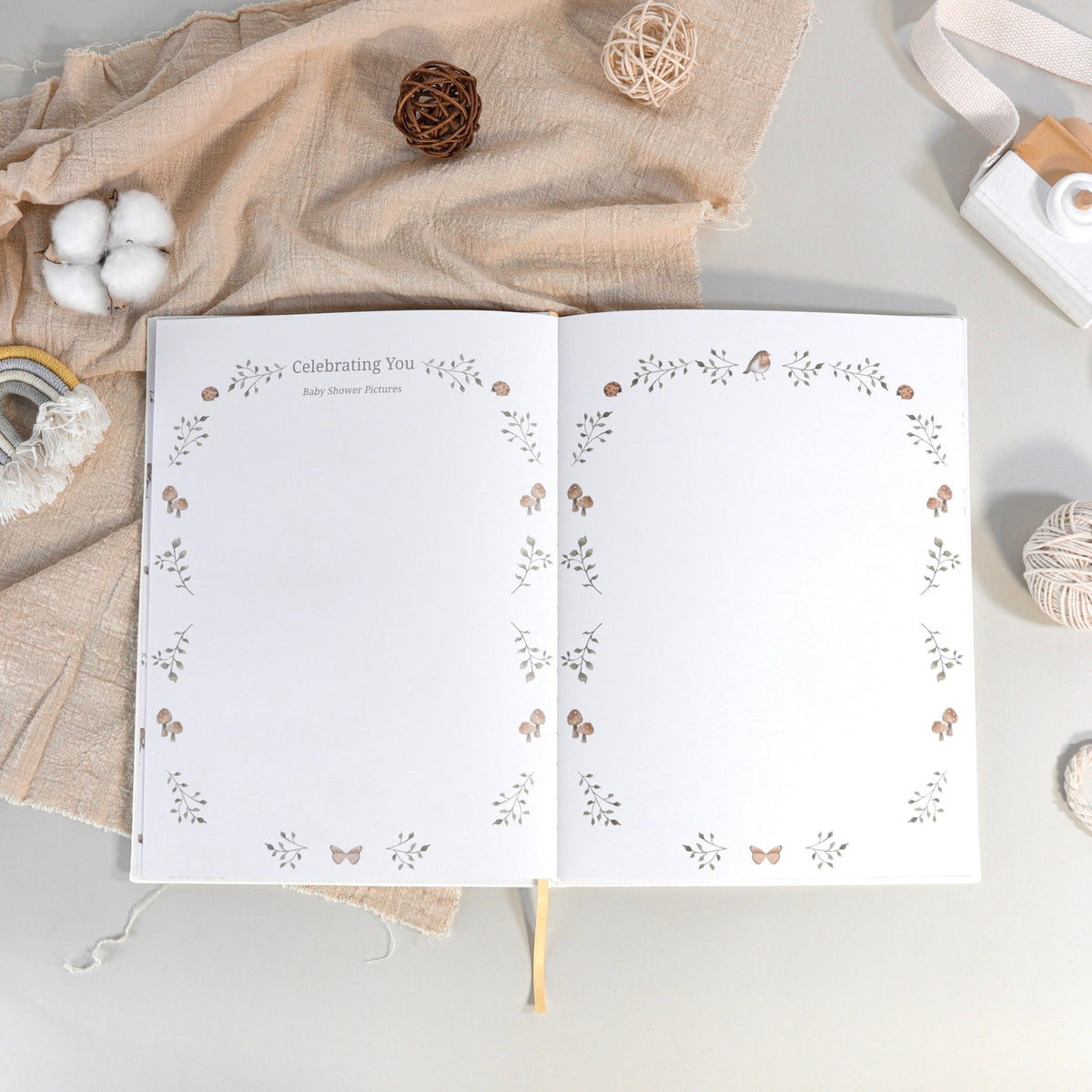 Open memory book spread with floral wreath border for baby celebration pages