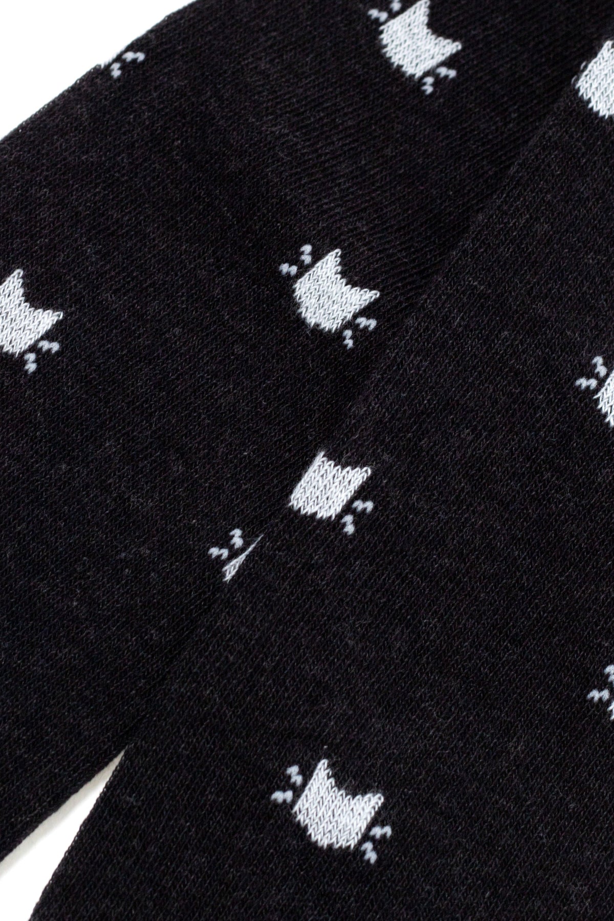 Black kids cotton tights close-up with scattered white cat silhouettes on knit fabric