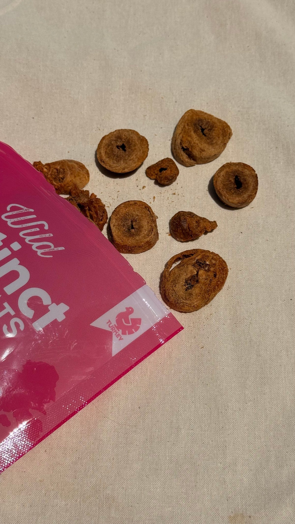 Freeze-dried turkey heart dog treats, small round pieces on a light surface