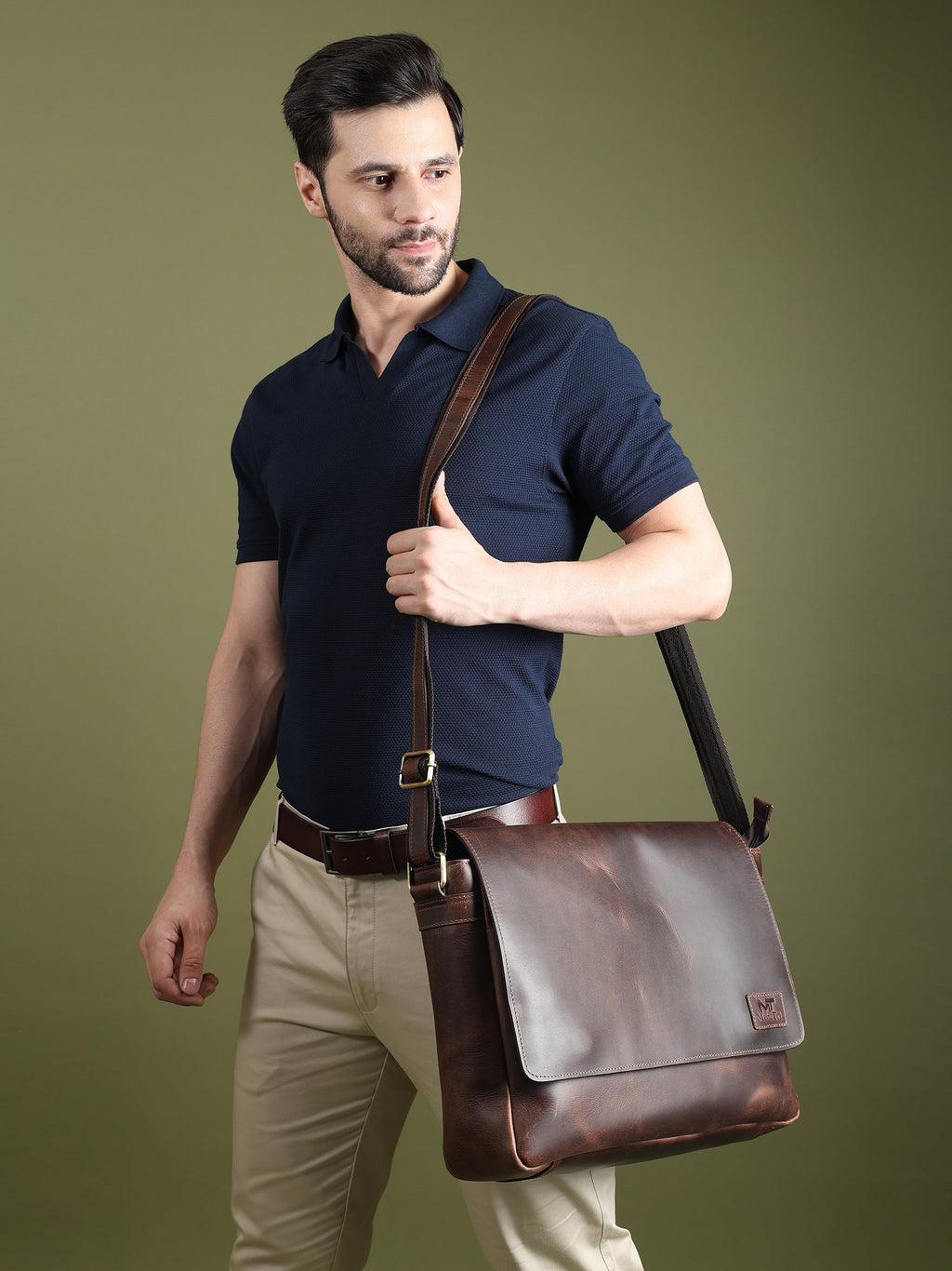 Genuine Sitka leather laptop bag worn crossbody with front flap, dark brown.