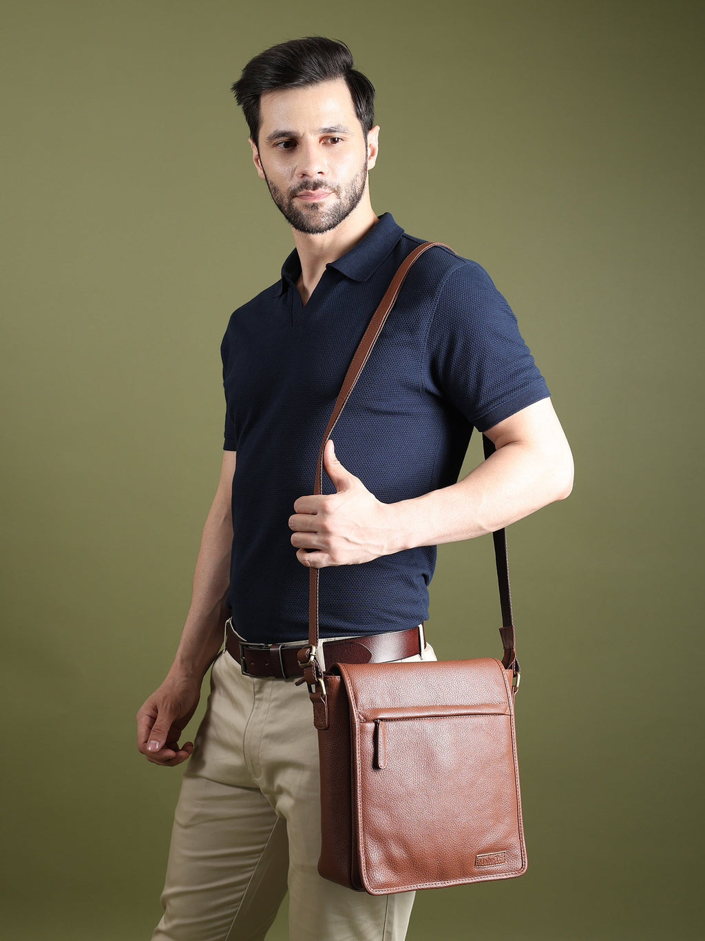 Brown leather crossbody bag on a person with adjustable shoulder strap