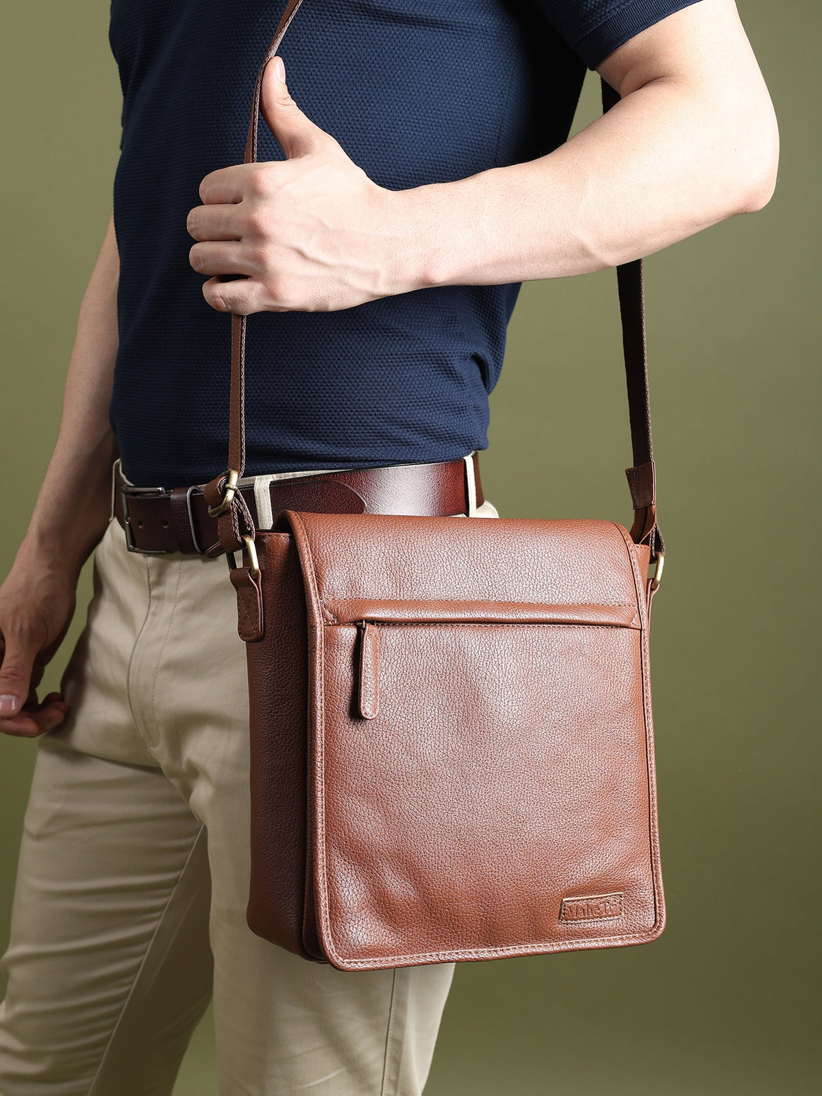 Brown leather crossbody bag worn across the chest with adjustable strap