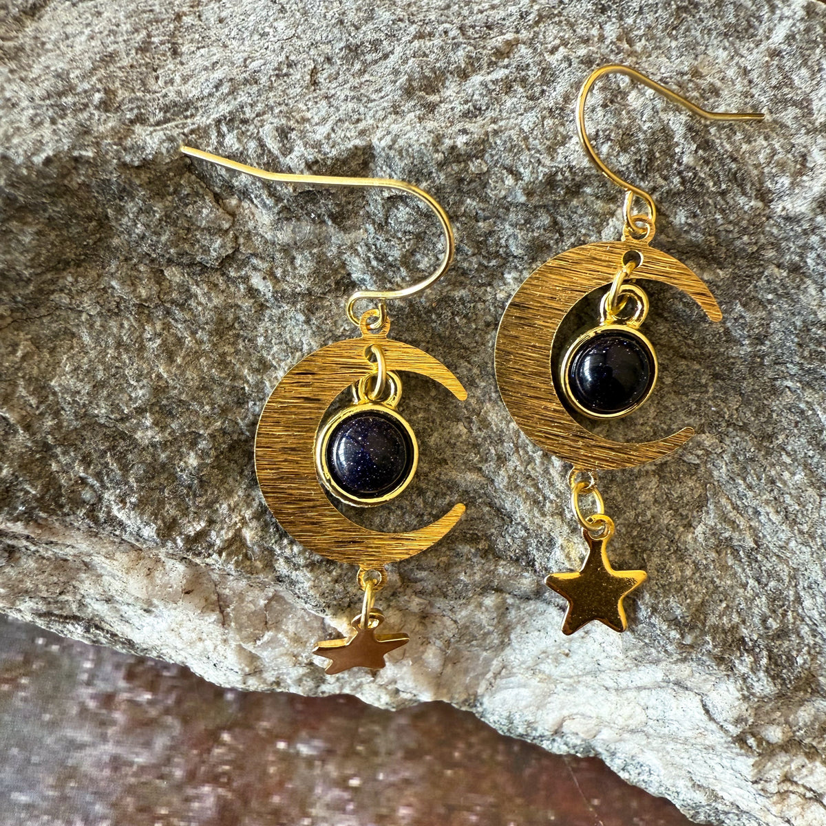 Textured gold crescent moon earrings with dark blue stones and star charm dangles