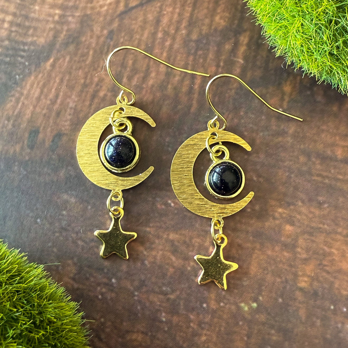 Gold crescent moon earrings with dark blue round stones and star dangle charms