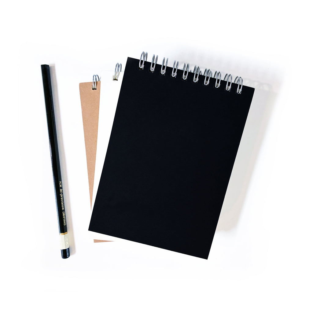 Black spiral notebook with metal coil binding and blank front cover