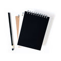 Black spiral notebook with metal coil binding and blank front cover