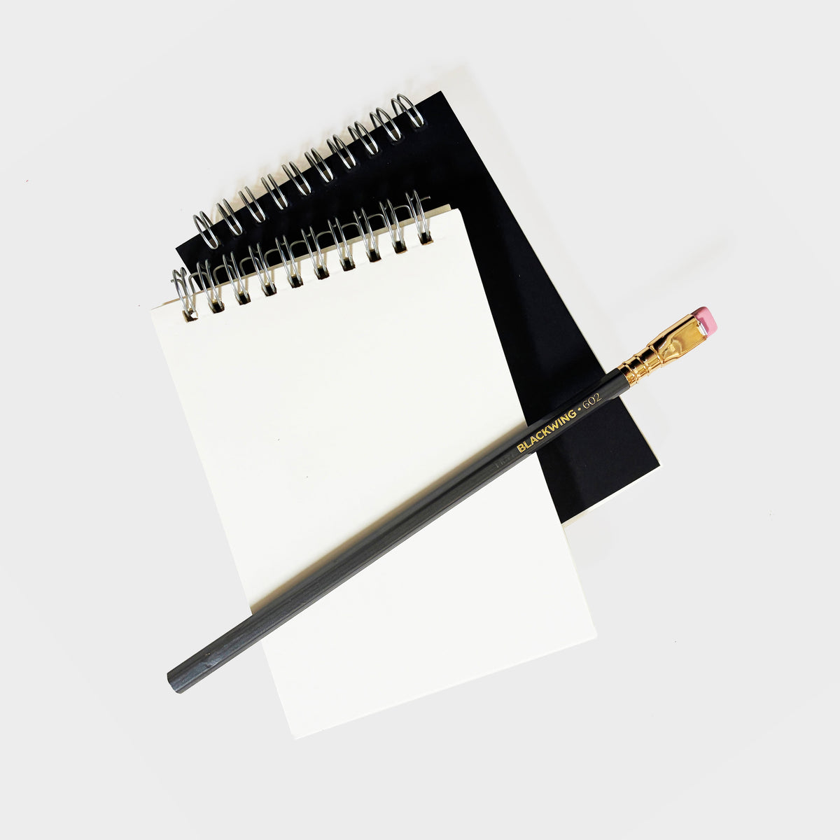 Black spiral notebook with metal coil binding and blank front cover