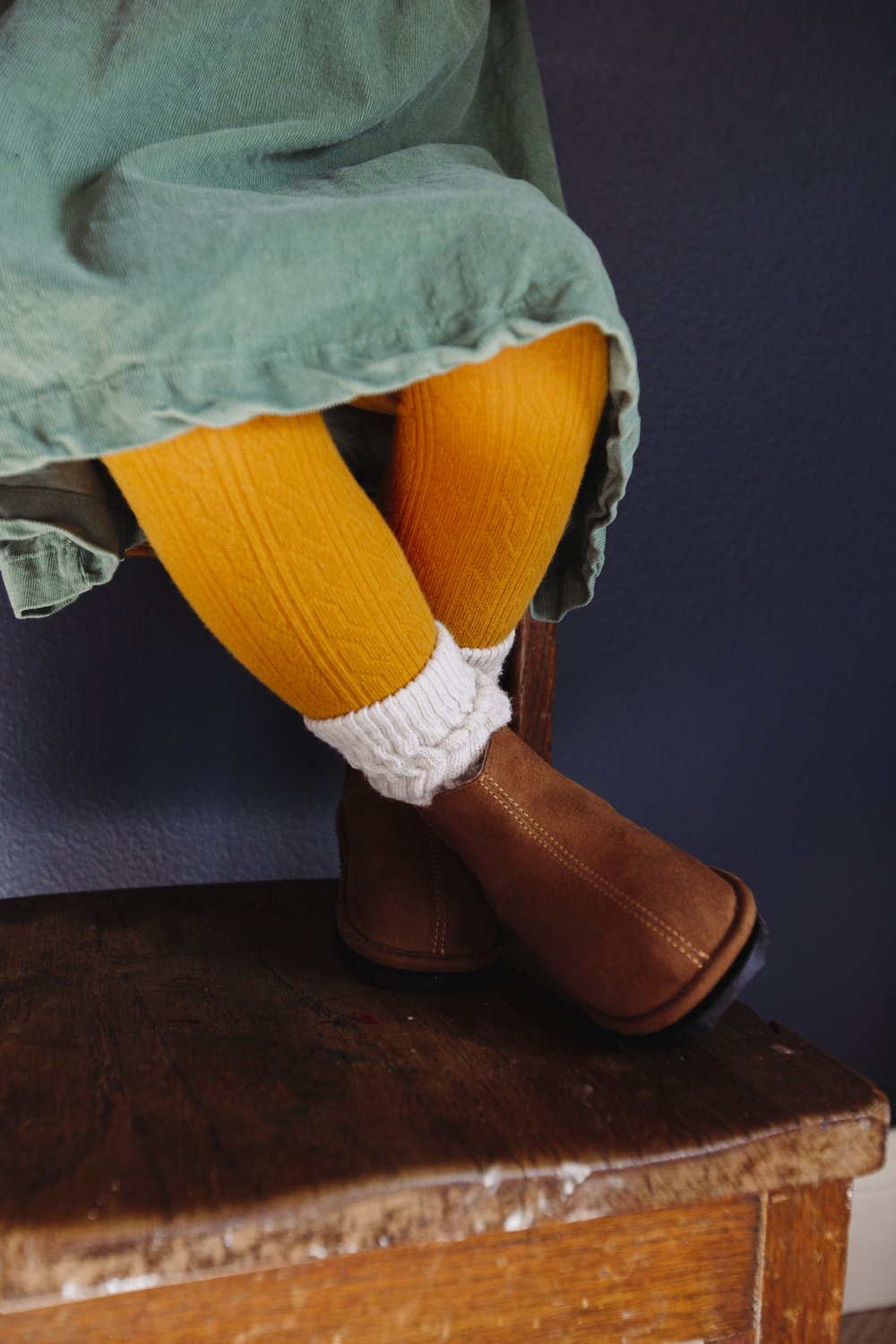 Kids brown Chelsea boots worn with yellow socks and white cuffs