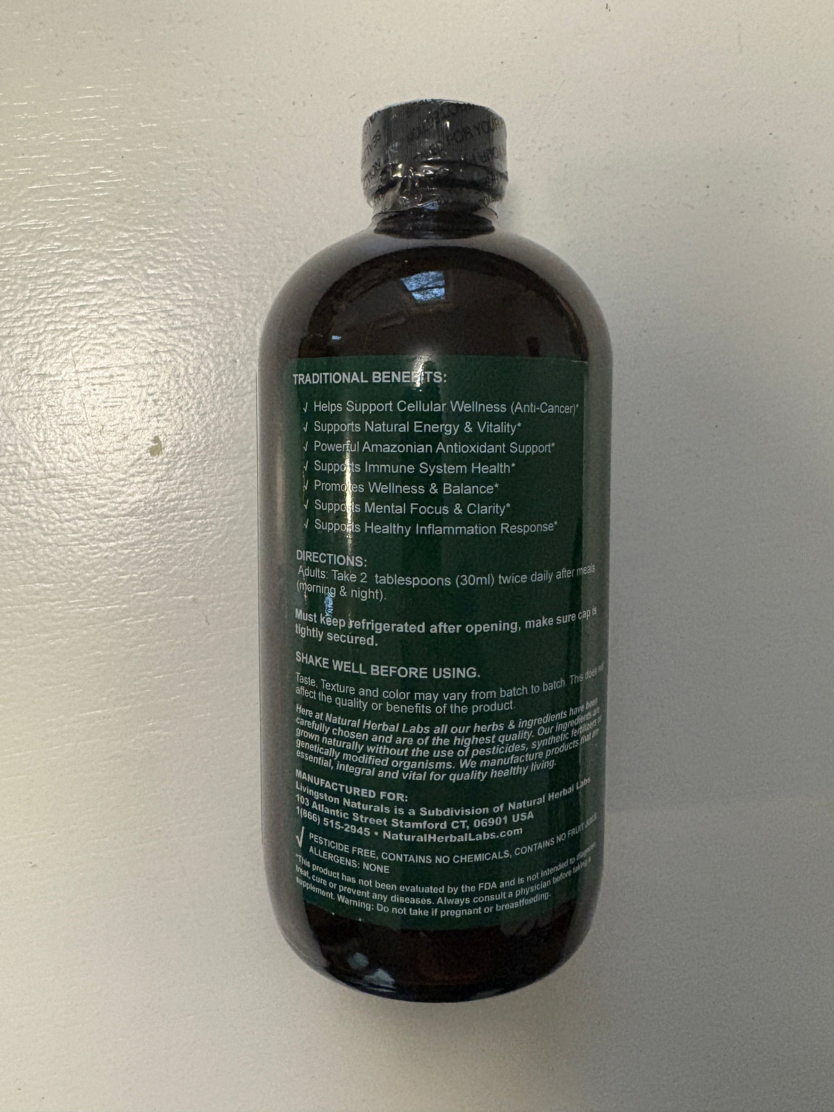 Amber herbal liquid blend bottle showing benefits, directions, and warnings on the back label
