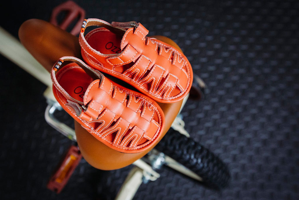 Orange kids sandals with double hook-and-loop straps and stitched cutout sides
