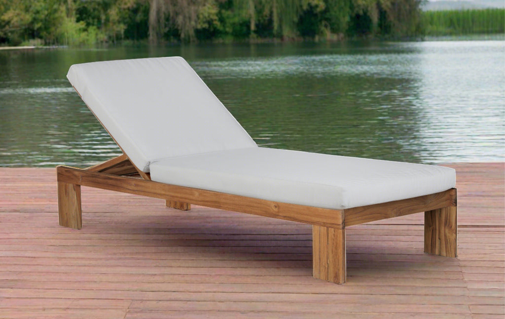 Outdoor teak chaise lounge with gray upholstered cushion and wooden frame