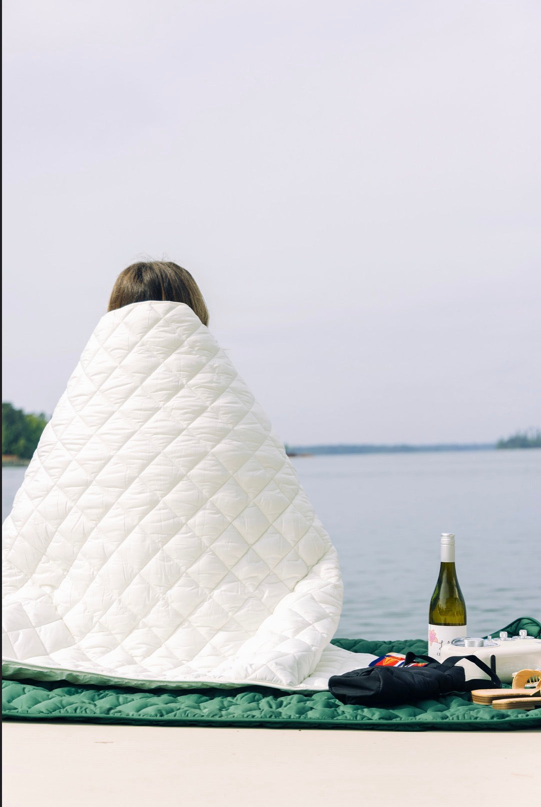 White quilted puffer blanket with stitched diamond pattern, folded into triangle