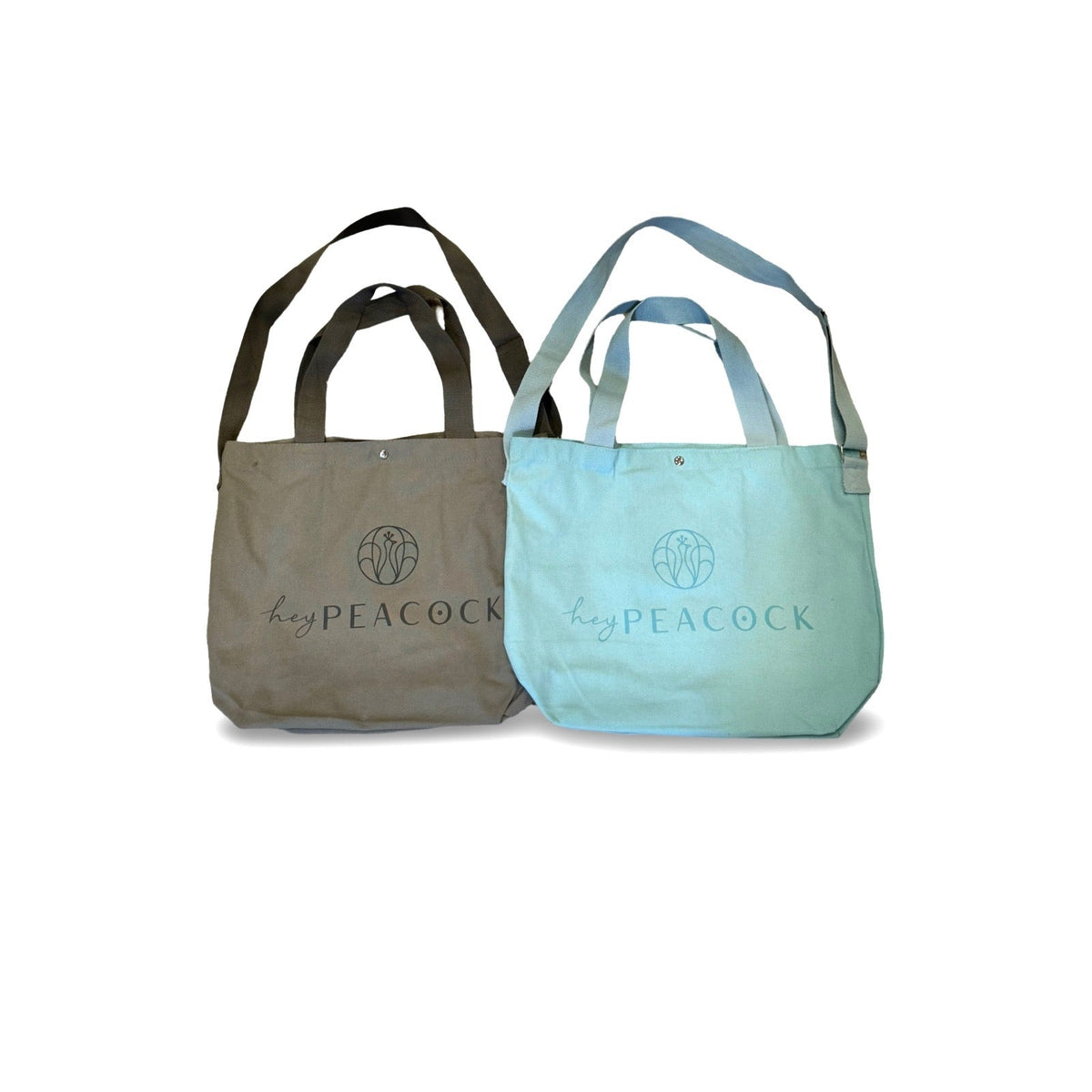 Gray canvas tote bag with two handles and HeyPeacock logo on front