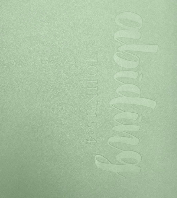 Mint green soft leather journal cover with embossed script and vertical text detail