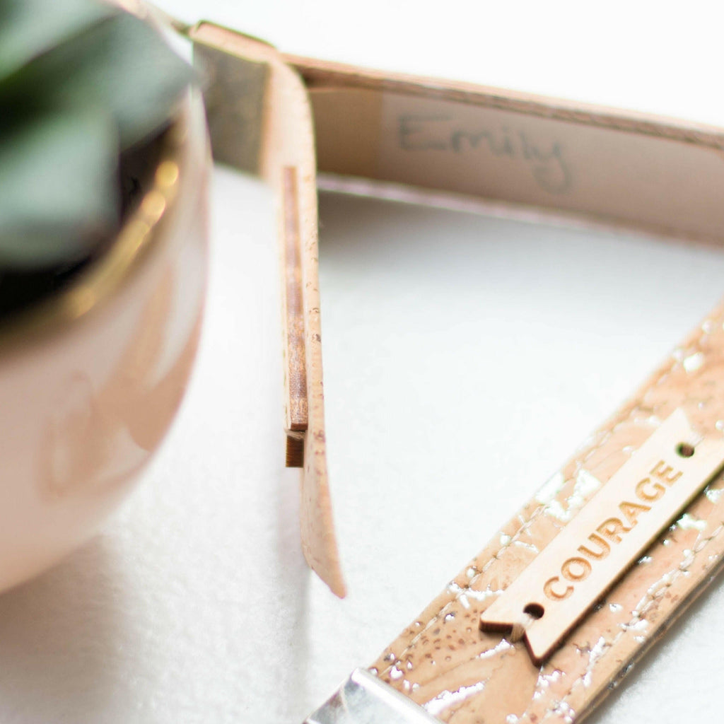 Zero waste luggage tag detail, “COURAGE” text on cork-look fabric with metal ring