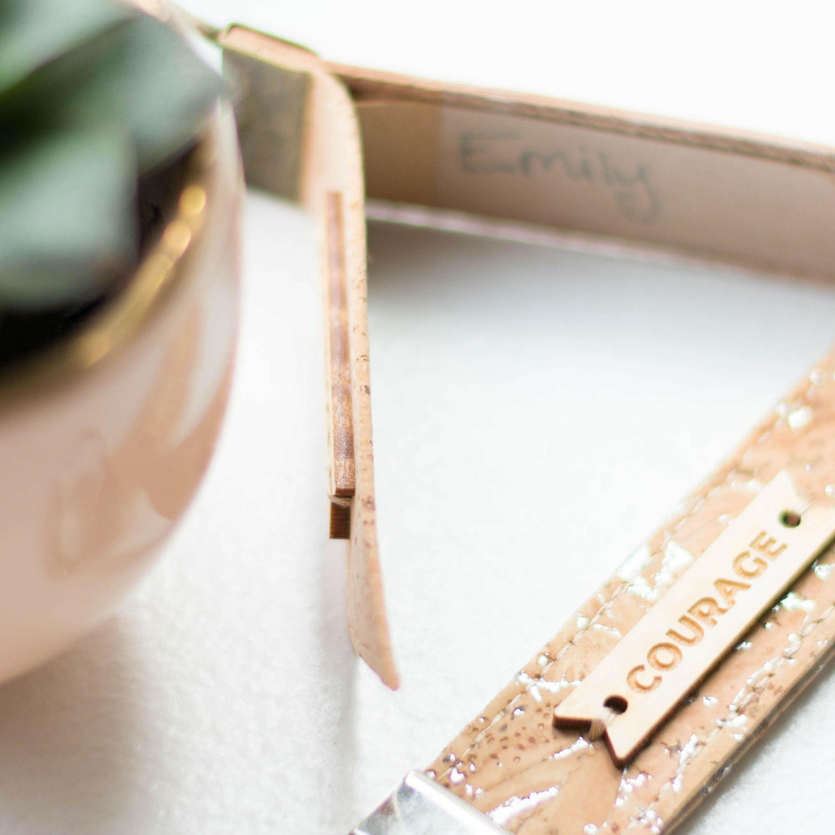 Zero waste luggage tag detail, “COURAGE” text on cork-look fabric with metal ring