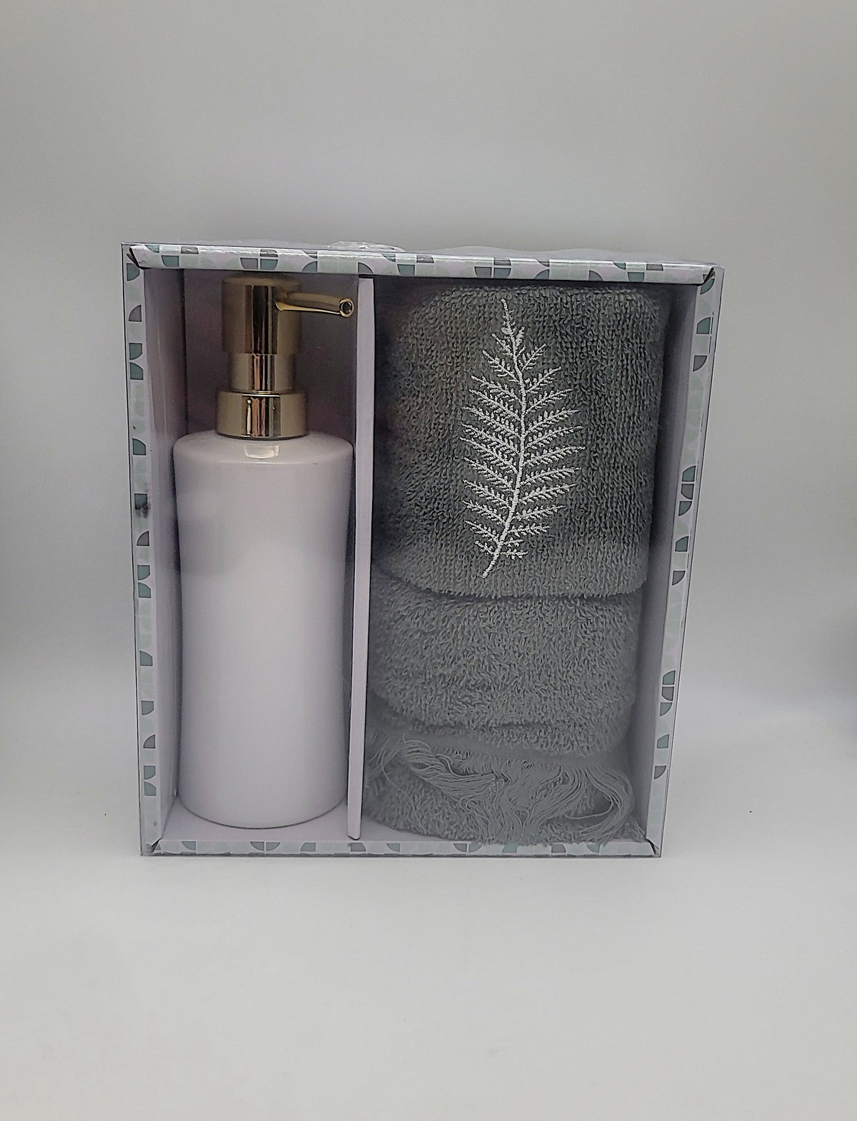 Open box set with soap pump bottle and two gray-green towels featuring fern leaf embroidery