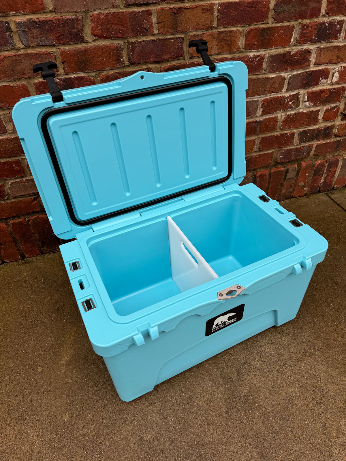 Opened Caribbean blue hard cooler with hinged lid and black front latches
