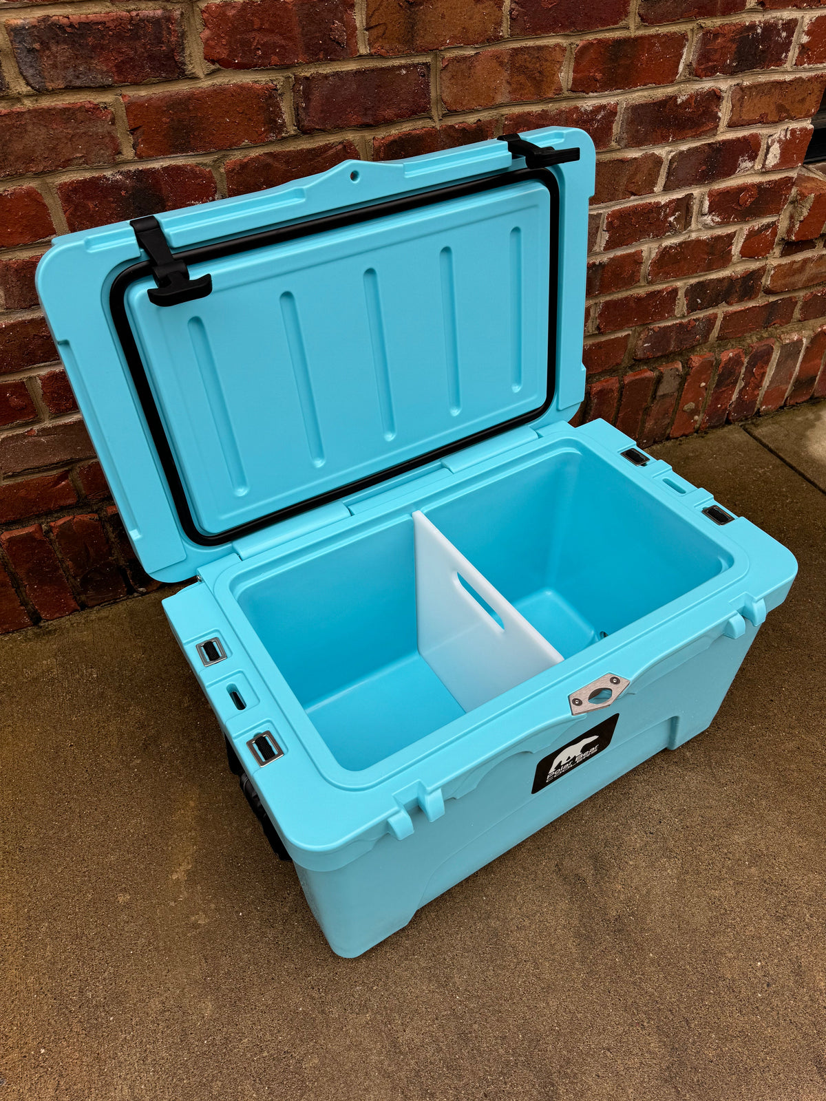 Light blue hard cooler open with white insert and hinged lid support posts