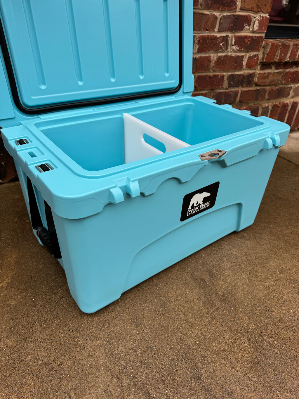 Light blue hard cooler with open lid and drain plug detail